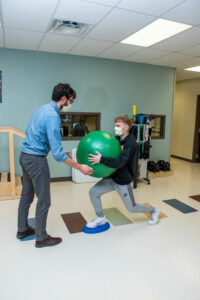 MRHC Physical therapist helping high school boy exercise
